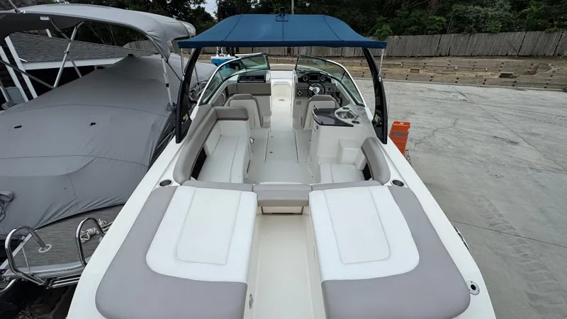 Slide: The Image of 2013 Sea Ray 270 SLX boat with spacious seating and blue canopy, docked outdoors. - 8