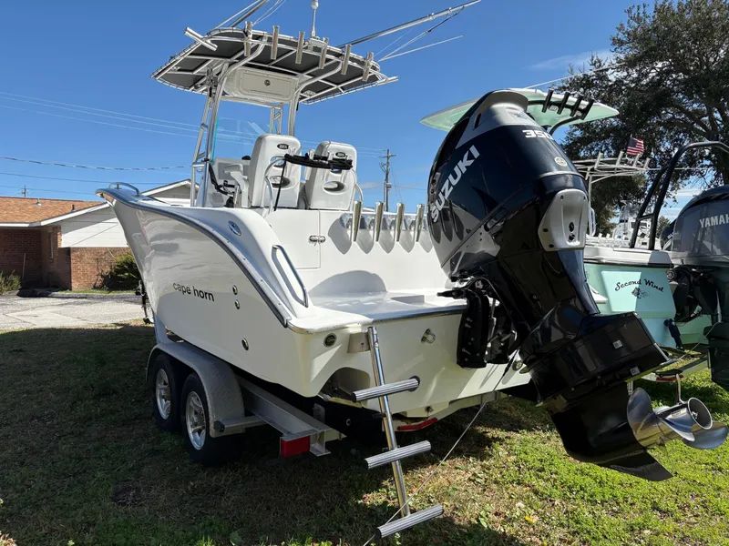 Slide: The Image of 2021 Cape Horn 22 OS boat with Suzuki outboard motor on trailer, parked outdoors. - 2