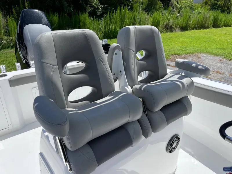Slide: The Image of 2021 Cape Horn 22 OS boat with dual gray cushioned seats and lush green background. - 4