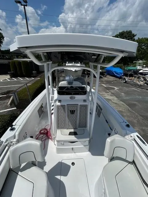 Slide: The Image of 2025 Wellcraft 222 Fisherman boat, white interior, center console, outdoor setting, partly cloudy sky. - 10