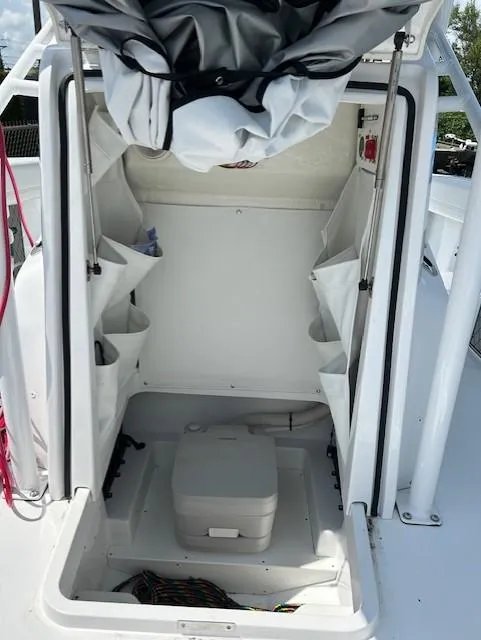 Slide: The Image of 2025 Wellcraft 222 Fisherman boat interior with storage compartments and portable toilet. - 11