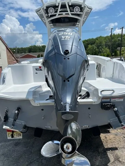 Slide: The Image of 2025 Wellcraft 222 Fisherman boat with powerful outboard motor, parked outdoors. - 4