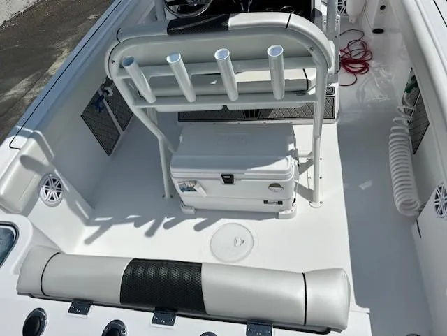 Slide: The Image of 2025 Wellcraft 222 Fisherman boat interior with seating, rod holders, and storage cooler. - 6