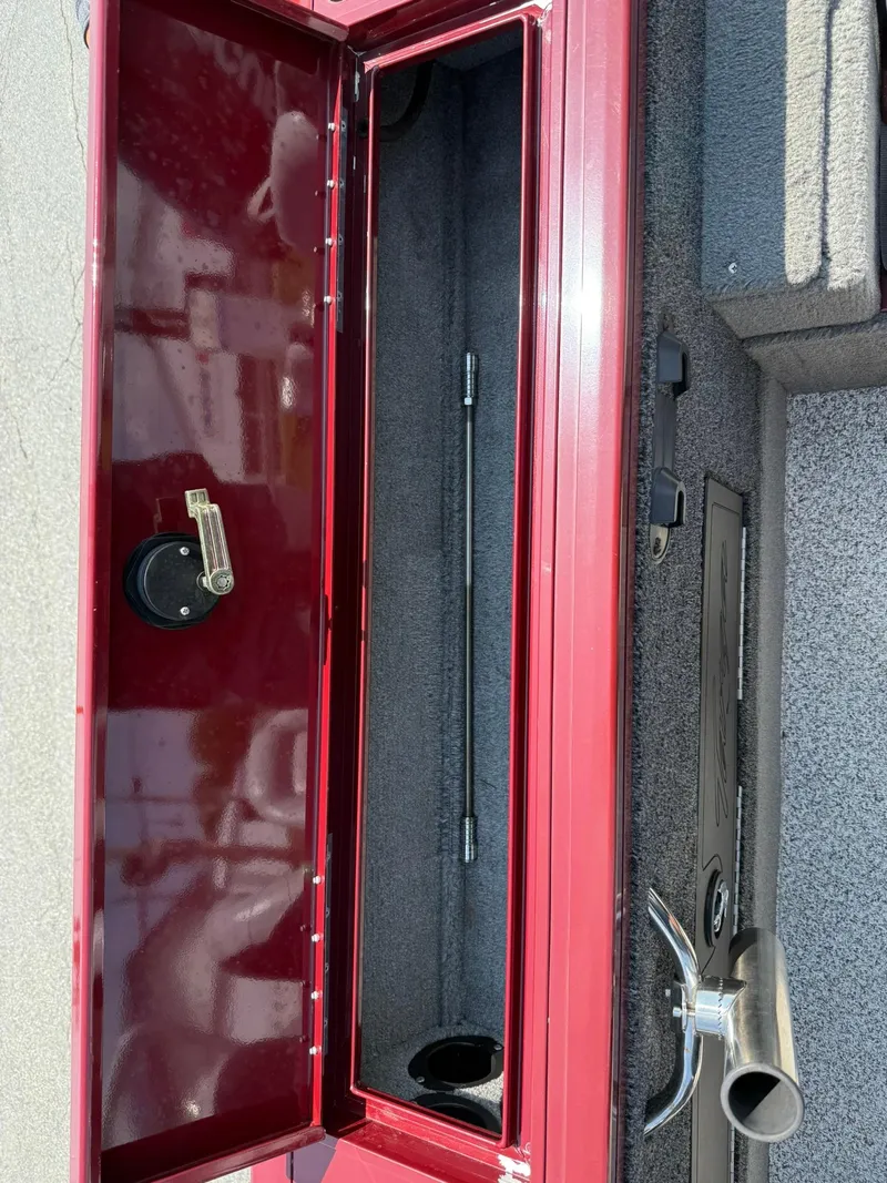 Slide: The Image of 2012 Tracker Targa V-18 Combo boat storage compartment with red interior and latch. - 15