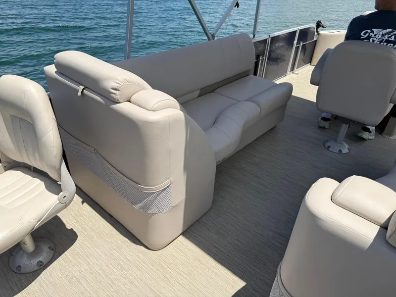 Slide: The Image of Interior of 2017 Silver Wave 230 Island CC boat with beige seating on water. - 16