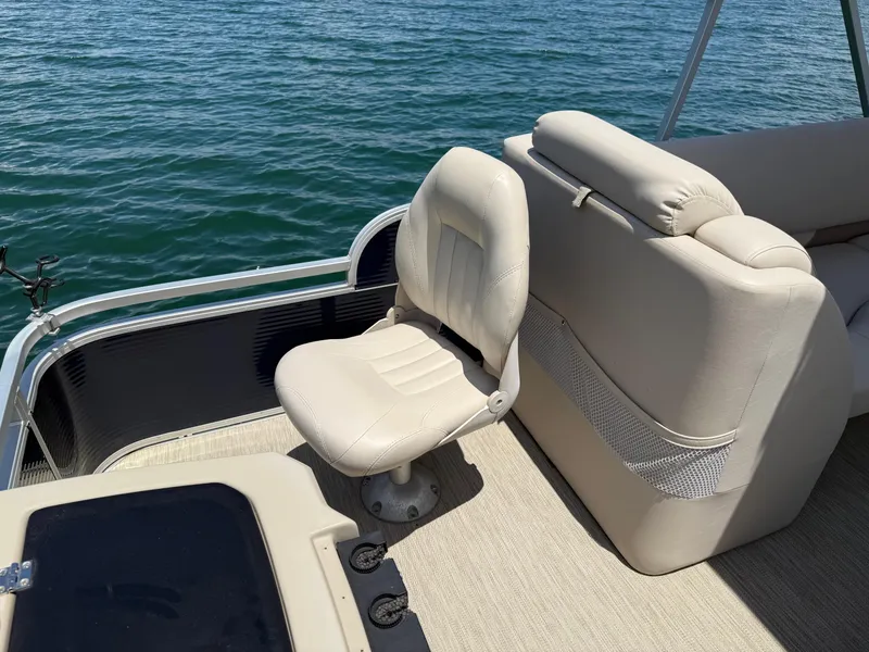 Slide: The Image of 2017 Silver Wave 230 Island CC boat interior with beige seating, on calm water. - 18