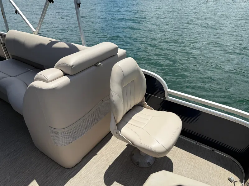 Slide: The Image of 2017 Silver Wave 230 Island CC boat interior with beige seating, overlooking calm water. - 19