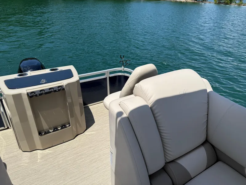Slide: The Image of 2017 Silver Wave 230 Island CC boat interior with plush seating on a serene lake. - 21