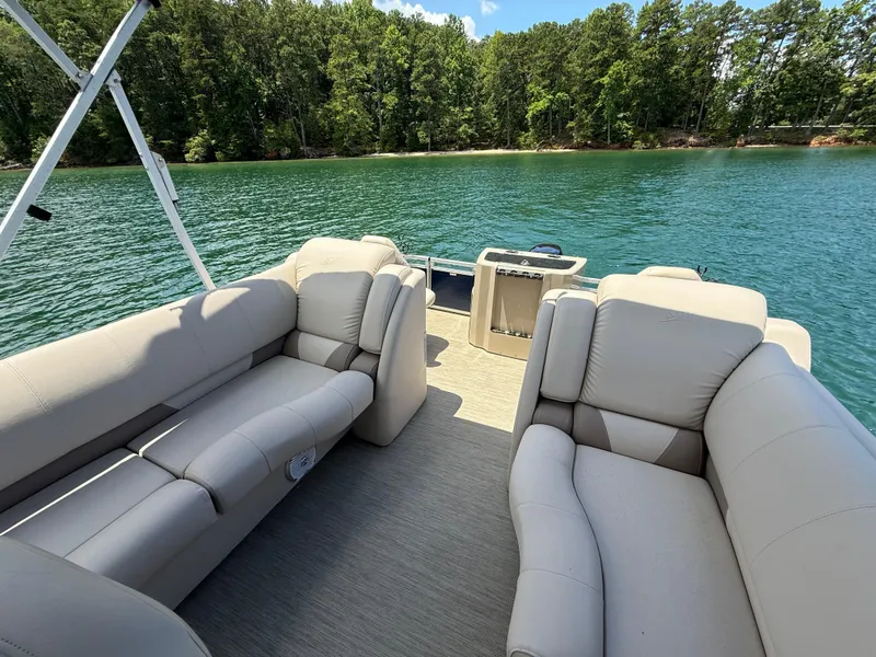 Slide: The Image of 2017 Silver Wave 230 Island CC boat interior with plush seating on a serene lake. - 9