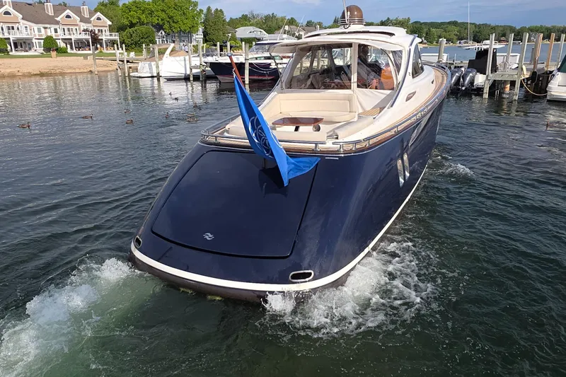 Slide: The Image of 2013 Zeelander Z44 yacht docked in a marina, featuring a sleek design and blue flag. - 10