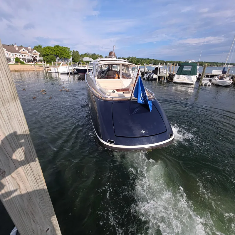 Slide: The Image of 2013 Zeelander Z44 yacht docked in a marina, with a blue flag waving. - 12