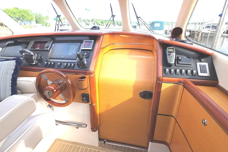 Slide: The Image of 2013 Zeelander Z44 yacht helm with wooden steering wheel and modern navigation controls. - 19