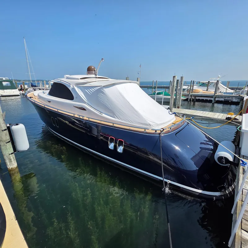 Slide: The Image of 2013 Zeelander Z44 yacht docked in marina, featuring sleek design and covered deck. - 2
