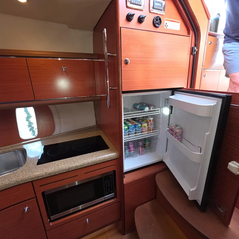 Slide: The Image of 2013 Zeelander Z44 yacht kitchen with open fridge, microwave, and stove. - 33
