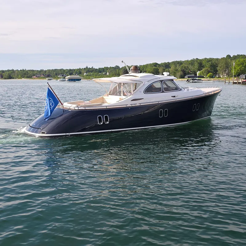 Slide: The Image of 2013 Zeelander Z44 yacht cruising on a serene lake with lush green shoreline. - 4