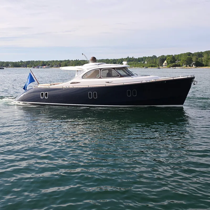Slide: The Image of 2013 Zeelander Z44 yacht cruising on a calm lake with scenic shoreline. - 5