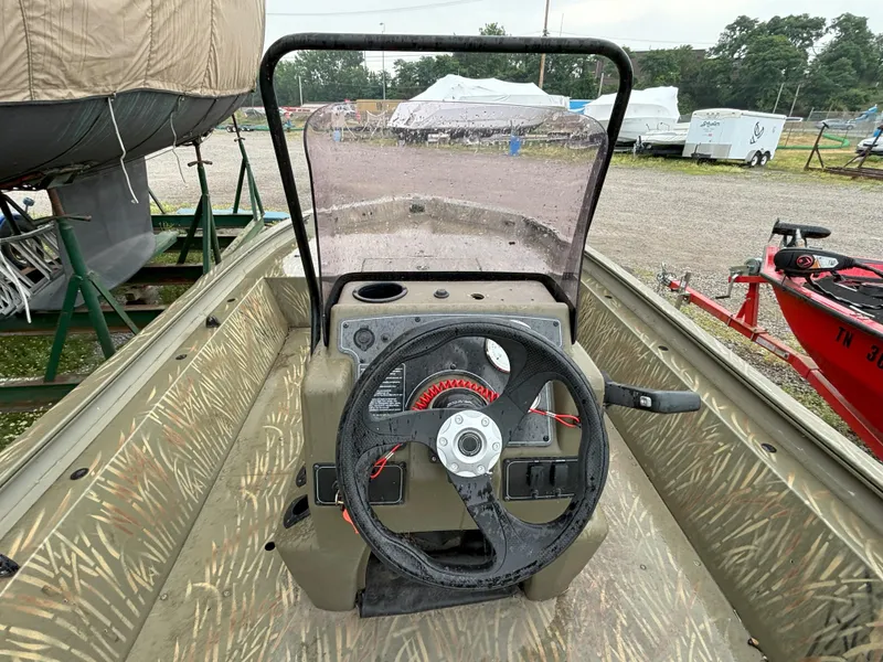 Slide: The Image of 2022 Tracker Grizzly 1860 CC boat interior with steering wheel and console. - 2