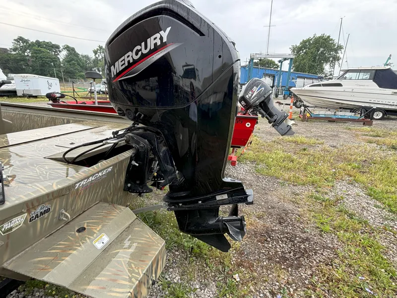Slide: The Image of 2022 Tracker Grizzly 1860 CC boat with Mercury outboard motor in a marina setting. - 4