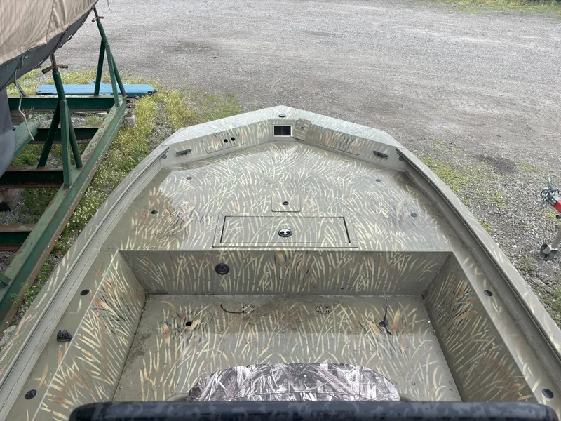 Slide: The Image of 2022 Tracker Grizzly 1860 CC boat with camouflage pattern, parked on gravel. - 9