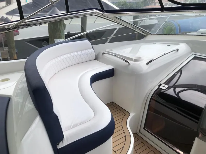 Slide: The Image of Luxurious seating area on a 2003 Sunseeker Portofino 46 yacht, featuring elegant white and navy upholstery. - 10