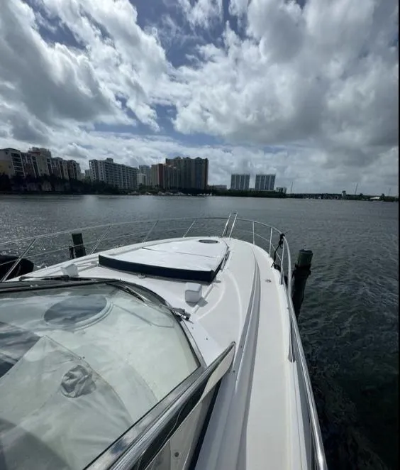 Slide: The Image of 2003 Sunseeker Portofino 46 yacht on water with city skyline and cloudy sky. - 26