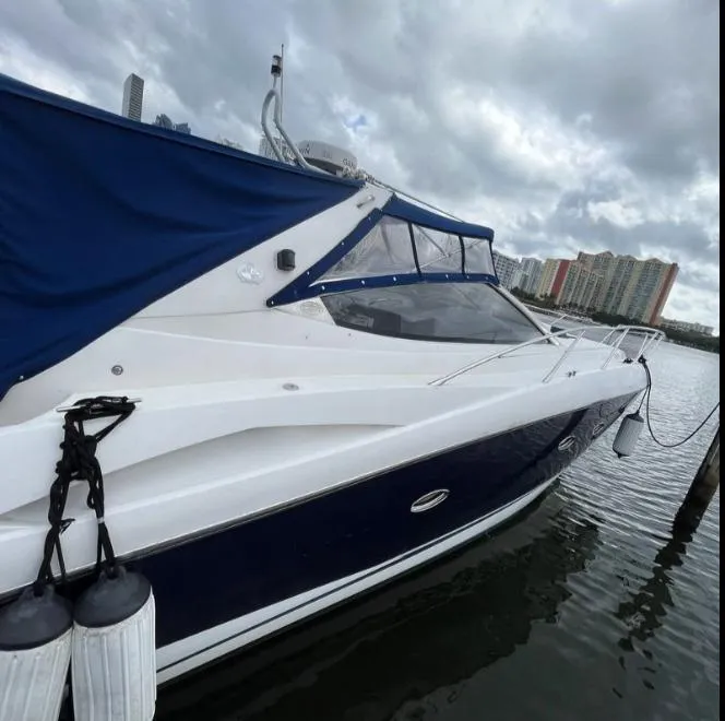 Slide: The Image of 2003 Sunseeker Portofino 46 yacht docked, featuring sleek design and blue canopy. - 31