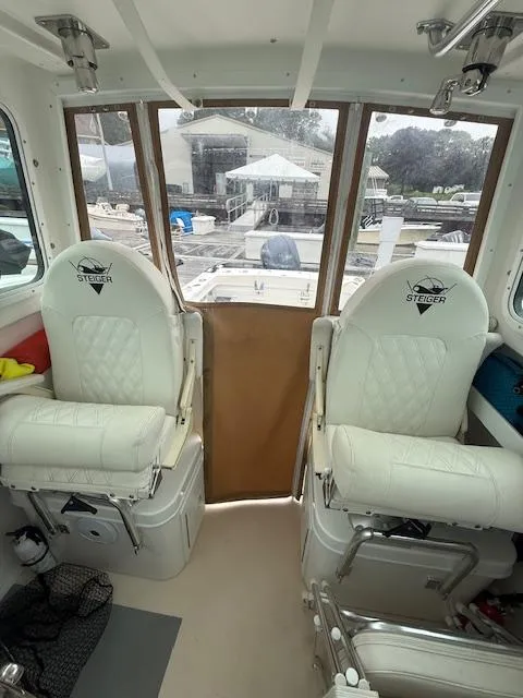 Slide: The Image of Interior of 2021 Steiger Craft 255 DV MIAMI boat with white seating and marina view. - 10