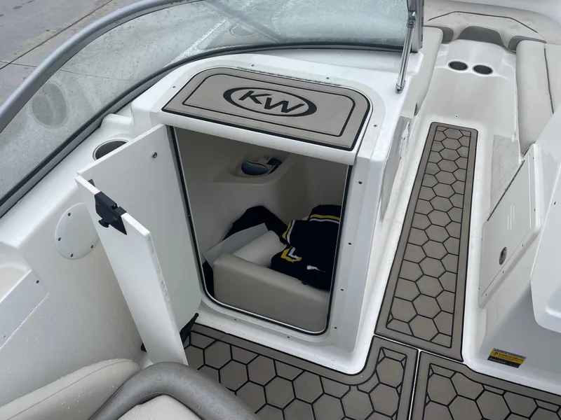 Slide: The Image of 2021 Key West 203 DFS boat interior storage compartment with open door and hexagonal floor design. - 10