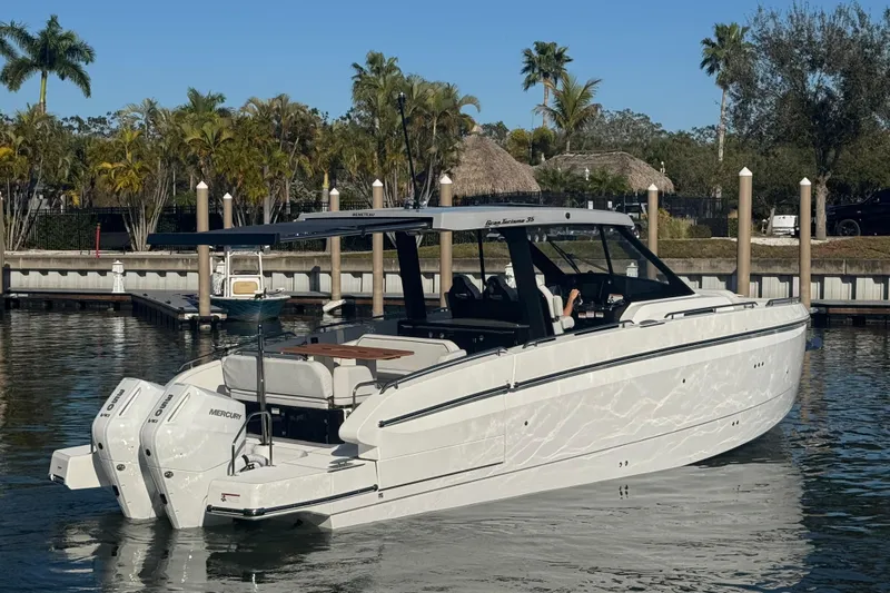 Slide: The Image of 2026 Beneteau Gran Turismo 35 yacht docked in a marina, surrounded by palm trees. - 18