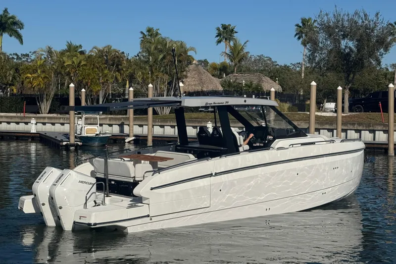 Slide: The Image of 2026 Beneteau Gran Turismo 35 yacht docked in a marina, surrounded by palm trees. - 19