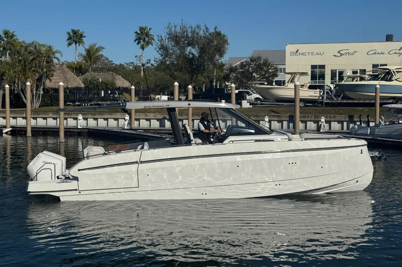 Slide: The Image of 2026 Beneteau Gran Turismo 35 yacht docked in a marina, surrounded by palm trees. - 21