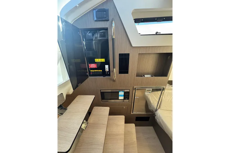 Slide: The Image of Interior of 2026 Beneteau Gran Turismo 35 yacht, featuring modern wood paneling and built-in appliances. - 22