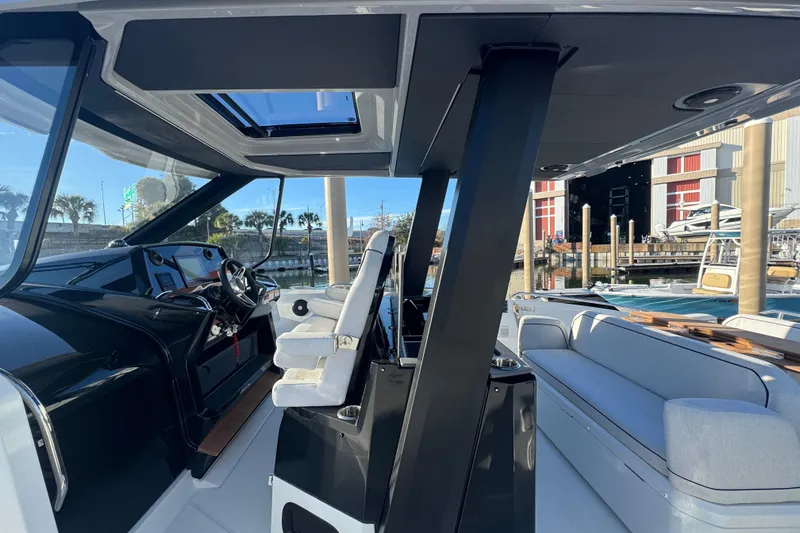 Slide: The Image of 2026 Beneteau Gran Turismo 35 interior with modern helm and seating, dockside view. - 27