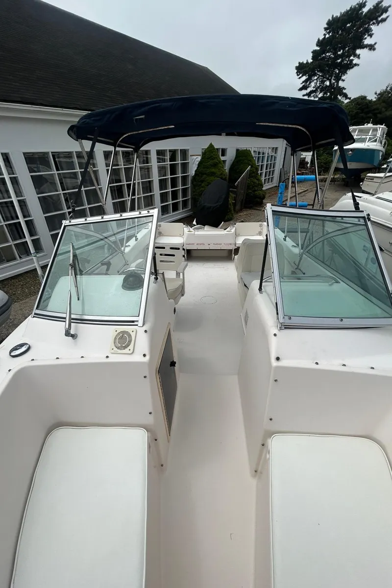 Slide: The Image of 1999 Grady-White 192 Tournament boat with open deck and dual windshields, docked near buildings. - 12