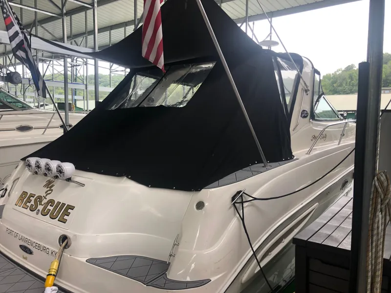 The Image of 1999 Sea Ray 460 Sundancer docked in a marina, showcasing sleek design and luxury seating. - 0