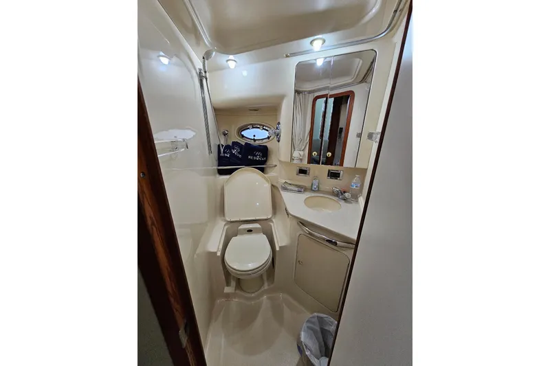 Slide: The Image of Bathroom interior of 1999 Sea Ray 460 Sundancer yacht, featuring toilet, sink, and mirror. - 19