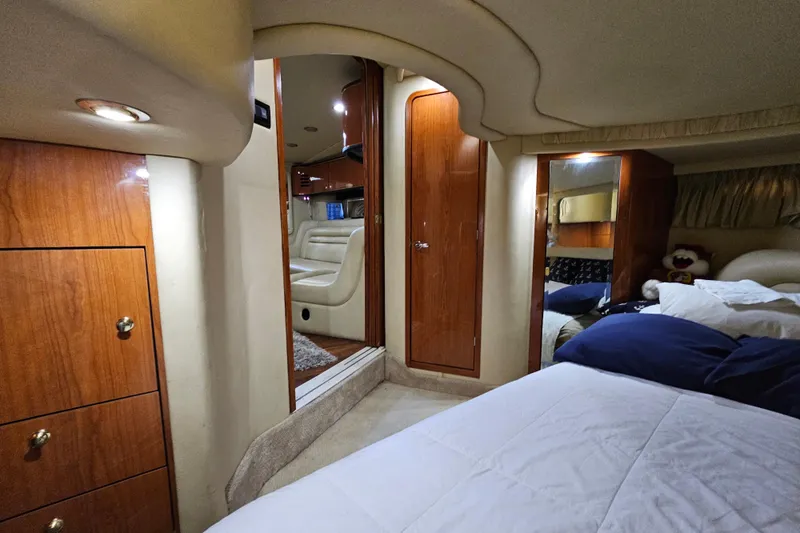 Slide: The Image of Interior of 1999 Sea Ray 460 Sundancer yacht, featuring cozy bedroom and elegant wood finishes. - 20