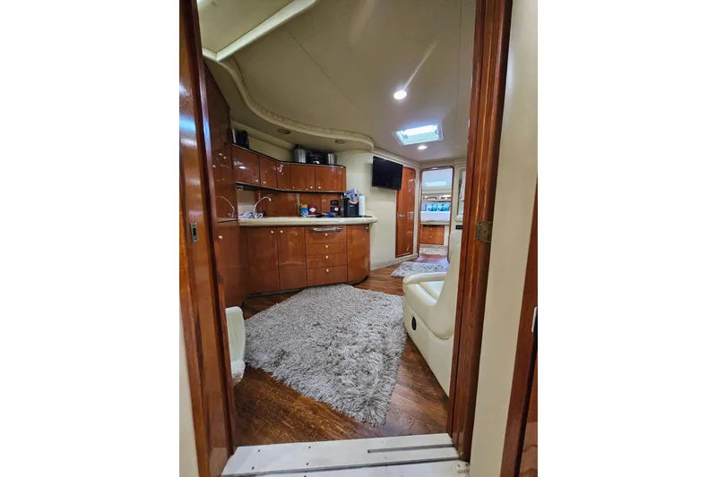 Slide: The Image of Interior of 1999 Sea Ray 460 Sundancer yacht with wood cabinetry and plush carpeting. - 21