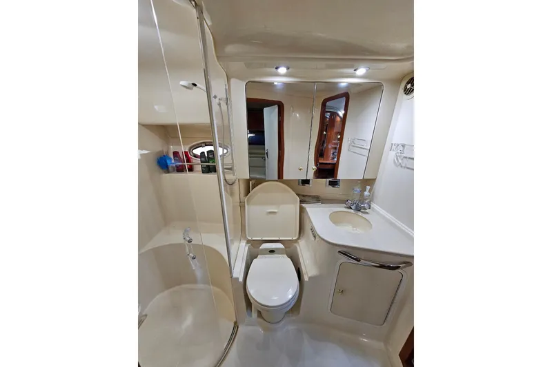 Slide: The Image of 1999 Sea Ray 460 Sundancer bathroom with shower, toilet, sink, and mirrored cabinet. - 28