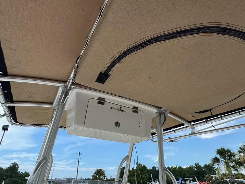 Slide: The Image of 2019 Key West 219 FS boat canopy and storage compartment under clear blue sky. - 12