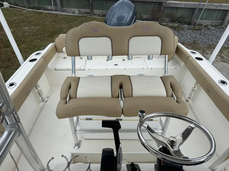 Slide: The Image of 2019 Key West 219 FS boat interior with beige seating and steering wheel. - 19
