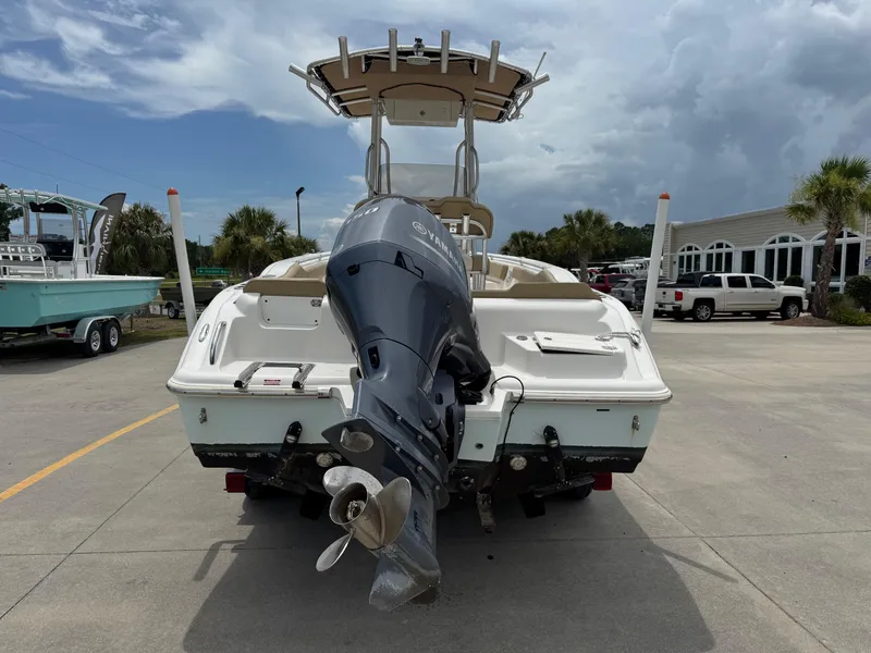 Slide: The Image of 2019 Key West 219 FS boat with outboard motor, parked on concrete under cloudy sky. - 4