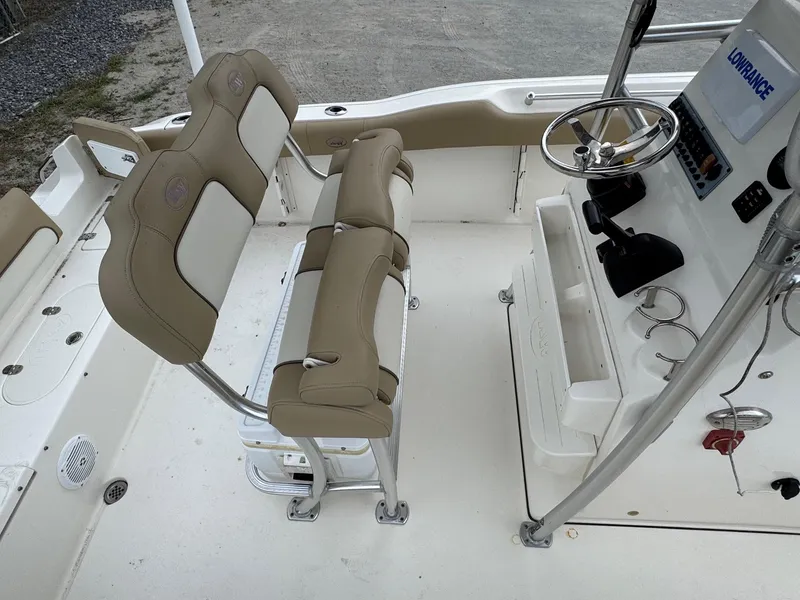 Slide: The Image of 2019 Key West 219 FS boat interior with beige seating and steering console. - 8