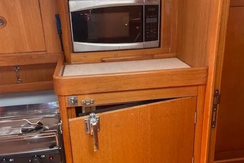 Slide: The Image of Wooden kitchen area in 2004 Wauquiez Centurion 40s yacht with microwave and storage. - 10