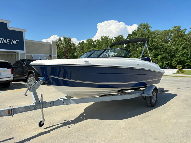Slide: The Image of 2021 Bayliner VR4 Bowrider OB on trailer, parked outdoors under clear blue sky. - 1