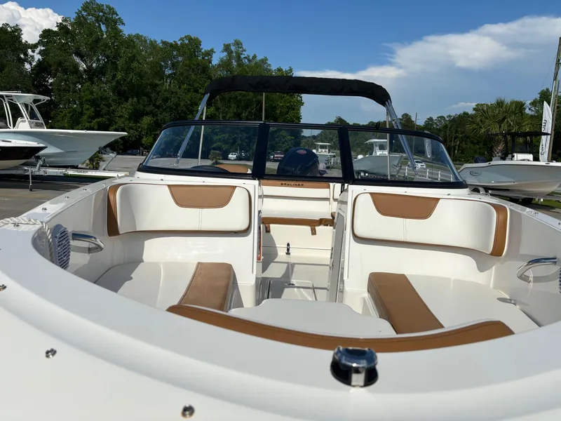 Slide: The Image of 2021 Bayliner VR4 Bowrider OB with tan and white seating, parked outdoors. - 4