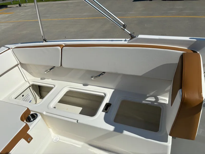Slide: The Image of 2021 Bayliner VR4 Bowrider OB interior seating with storage compartments and cup holder. - 7