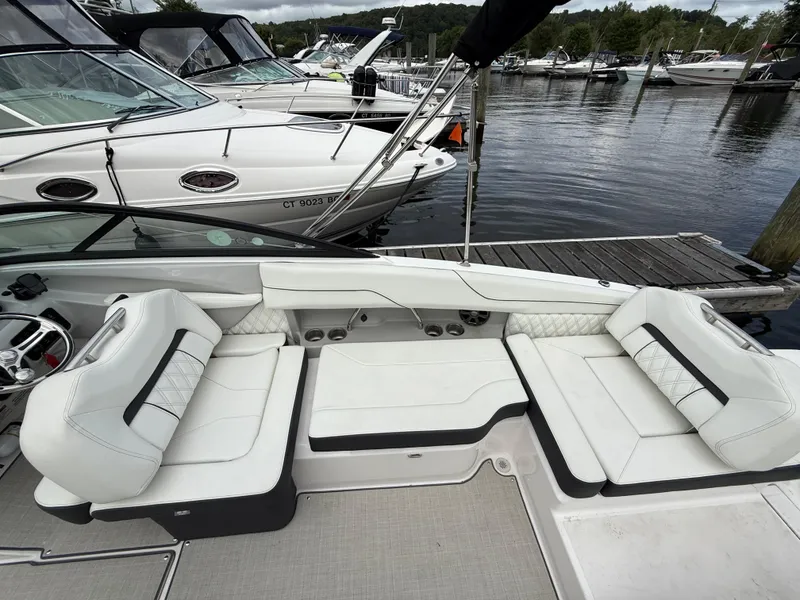 Slide: The Image of 2022 Regal LX2 boat interior with white seating at a marina dock. - 12