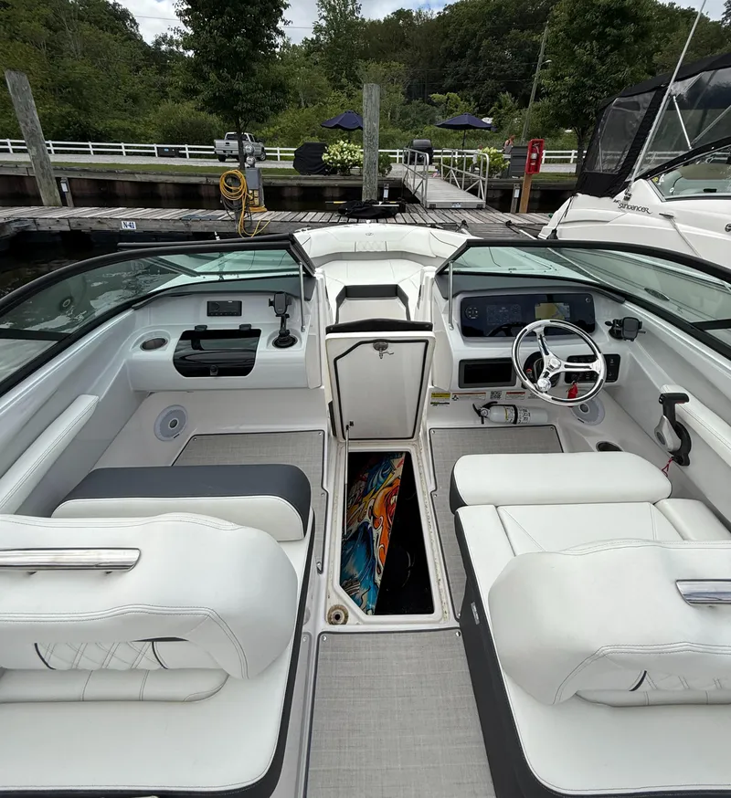 Slide: The Image of Interior of a 2022 Regal LX2 boat with white seating and modern dashboard. - 21