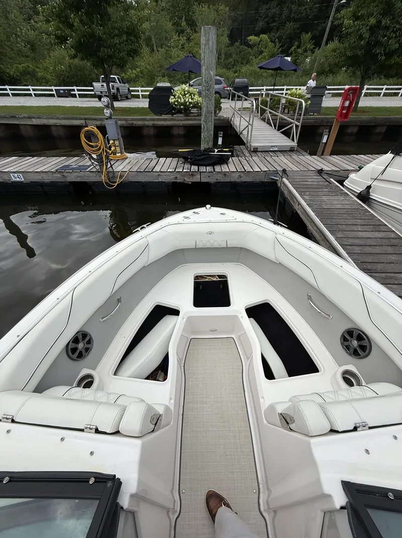 Slide: The Image of 2022 Regal LX2 boat docked at a marina with white seating and speakers. - 26